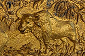 Luang Prabang, Laos - Wat Mai the gilded stucco engravings of the veranda. They narrate the Vessantara Jataka with various animals engraved at the base of the relief.
